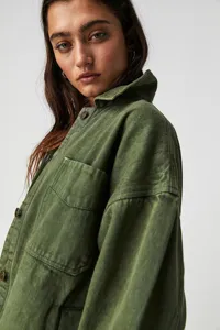 Close-up detail of women's olive green denim utility jacket featuring chest pocket and buttons.