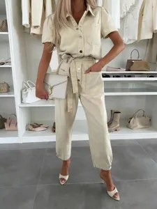 Casual beige denim jumpsuit for women, short sleeve utility romper with belt and pockets.