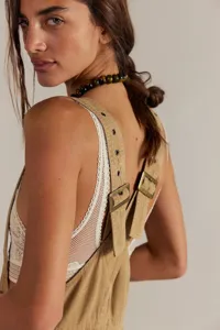 Vue détaillée de salopettes en jean sans manches décontractées avec boucles et œillets métalliques.