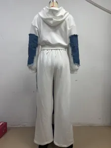 Back view of women casual two-piece hoodie and pants with denim patchwork and rivets.