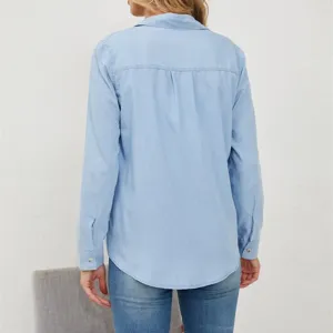 Women's light blue long sleeve denim shirt with turn down collar and button closure.