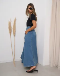 Detailed side view of a high-waisted denim maxi skirt paired with a simple black top.