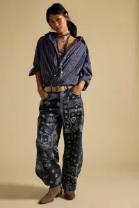 Detailed view of women's casual loose-fit mid-waist paisley print denim jeans and striped shirt.