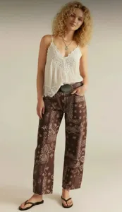 Detailed view of women casual loose mid rise paisley print straight leg denim jeans styled with a lace camisole.