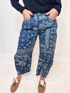Detailed view of women's loose mid-rise blue denim pants featuring a stylish white paisley print.