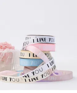 Vue détaillée des rouleaux de ruban coloré de 2.5cm avec I LIKE YOU pour de beaux nœuds.