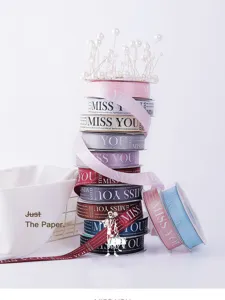 Detailed view of 2.5cm printed ribbon with alphabet text for floral packaging and DIY crafts.