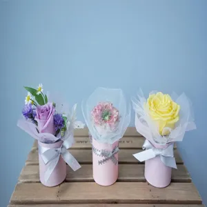 Mini flower buckets set with pink cylindrical boxes, tulle wrapping and elegant ribbons for gifts.