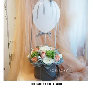 Runde Leder Blumen-Geschenkbox mit Ballon-Dekoration und frischem Blumengesteck für Feiern.