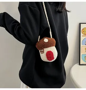 Detail shot of a handcrafted cute crochet mushroom bag worn across the shoulder.