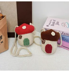 Detailed view of two cute hand-knitted mushroom house crochet mini crossbody bags
