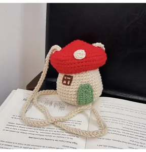 Detailed view of a handmade red crochet mushroom-shaped mini crossbody bag with braided strap