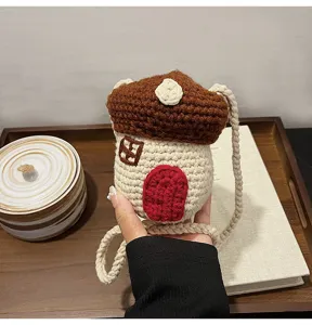 Close-up view of a cute handmade crochet mushroom mini bag featuring a red door detail and strap
