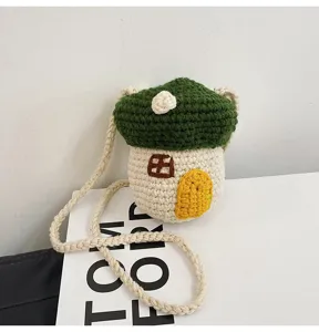 Close-up of handmade green crochet mushroom house mini crossbody bag with rope strap