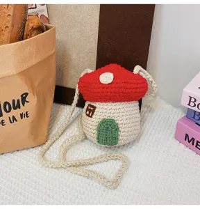 Close-up of cute handmade crochet mushroom house mini crossbody bag with knitted strap