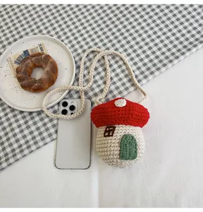 Hand-knitted mushroom-shaped crochet crossbody bag with rope strap on lifestyle background