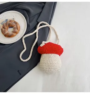 Detailed view of a handmade red crochet mushroom bag with white braided shoulder strap