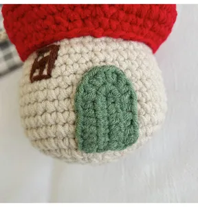 Close-up of a handmade crocheted mushroom house bag showing green door detail
