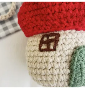 Close-up detail showing the intricate handmade crochet texture of the red mushroom bag.