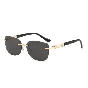 Bügellose Sonnenbrille für Damen mit luxuriösen Perlenbügeln und schicken goldenen Details.