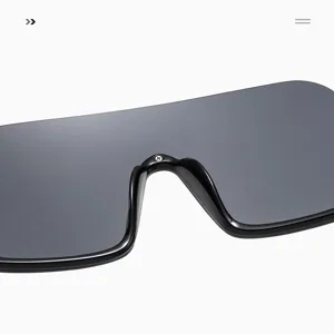 Primo piano dettaglio occhiali da sole maschera oversize stile Y2K montatura nera.