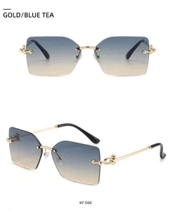 Lunettes de soleil carrées sans monture chic pour femmes avec branches de chaîne dorées.