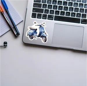 Detailed close-up view of dark blue vintage scooter sticker on a modern laptop surface.