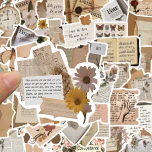 Close up detail of vintage aesthetic journaling stickers featuring old newspaper and floral design.