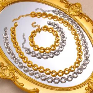 Close-up detail of chunky gold and silver geometric O-chain necklaces and matching bracelet set.