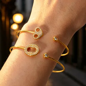 Nahaufnahme des vergoldeten Offenen Armreifs glitzernd mit Zirkoniasteinen im Detail.
