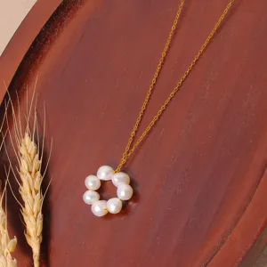 Close-up of pearl pendant necklace detail on wooden tray, elegant daily wear fashion accessory.