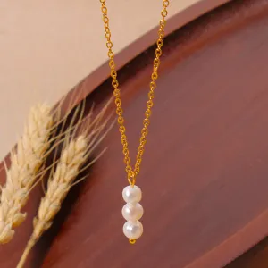 Gold chain necklace detail featuring three vertical white pearl pendants for daily styling.