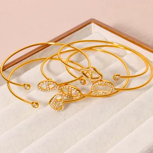 Detailaufnahme von 18K vergoldeten Zirkon-Armreifen mit offenem Design im Samt-Schmucktablett.