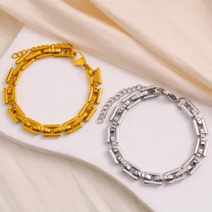 Detalle de elegantes pulseras de eslabones gruesos dorados y plateados con diseño geométrico.