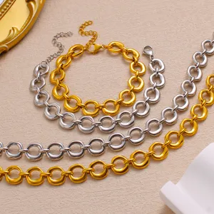 Close-up detail of stylish stainless steel geometric chain jewelry in gold and silver colors.