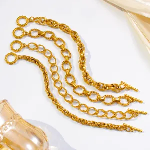 Close-up of gold-plated chunky twist chain bracelets detail showing refined metallic luster and design.
