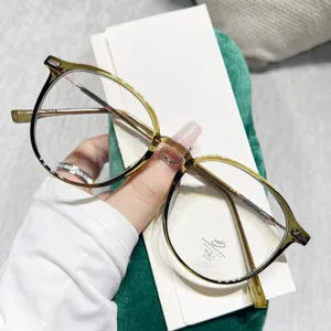 Primer plano de gafas redondas con filtro de luz azul, patillas de metal y lentes transparentes.