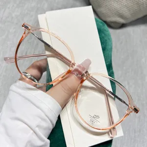 Detalle de gafas redondas transparentes anti luz azul, montura rosa ligera y elegante.