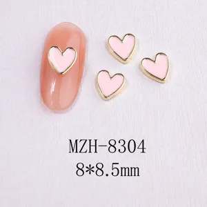 Detailed view of pink heart nail charms with gold metal borders, sized 8x8.5mm for nail art