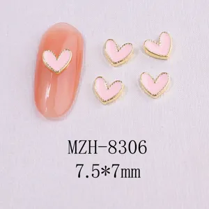 Close-up detail of pink enamel heart nail art charms with gold metal borders 7.5x7mm