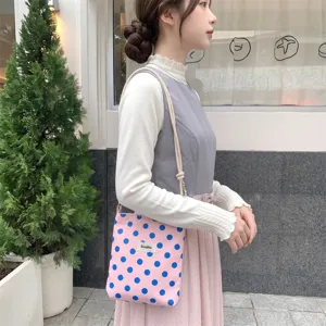 Detail van roze crossbodytas met stippen en verstelbare knoopkoordriem op model