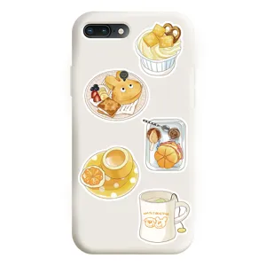 Vue détaillée d'une coque de téléphone blanche ornée de jolis stickers alimentaires jaunes.