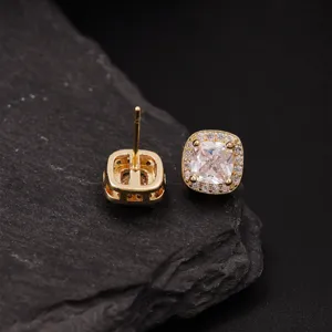 Gedetailleerde close-up van elegante gouden oorknopjes met schitterende zirkoniastenen.