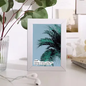 Detailed shot of a white photo frame with a green plant art print, perfect for table decor.