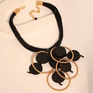 Dettaglio della collana boho in corda di cera con anelli d'oro e dischi neri