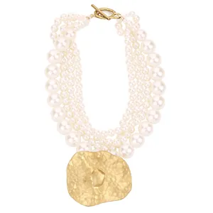 Collar de varias capas de perlas artificiales con un gran colgante de oro martillado