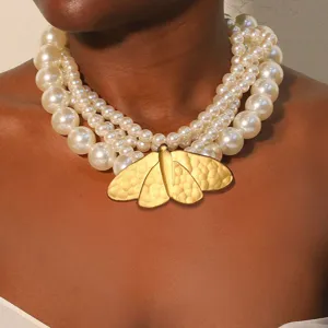 Elegante collar de perlas artificiales multicapa con colgante de polilla dorada martillada