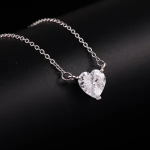 Detailed shot of a silver-tone heart crystal pendant clavicle chain fashion accessory.