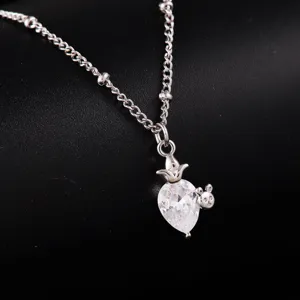 Close-up detail of silver clavicle chain with a teardrop crystal and cute rabbit pendant.