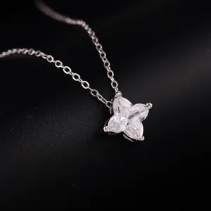 Silver chain necklace with a delicate four-petal crystal pendant, minimalist detail shot.
